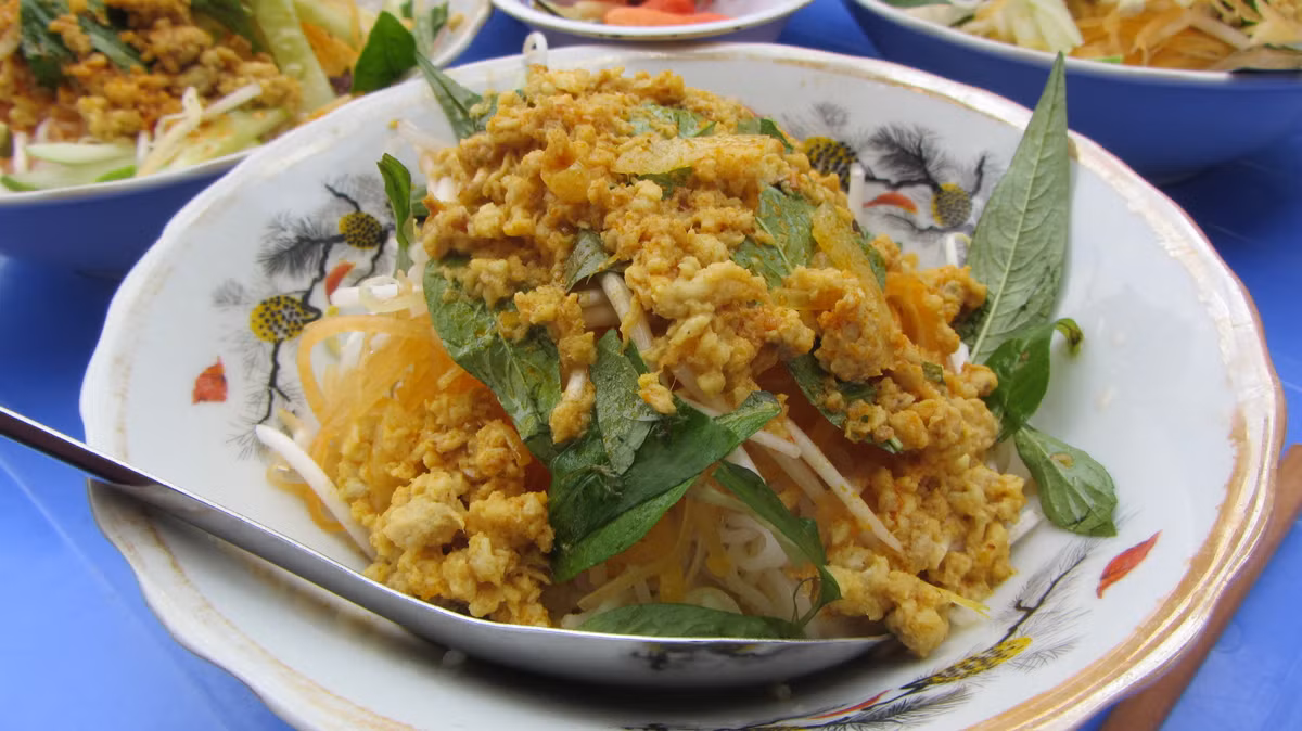 Thịt cá được nấu chung với các gia vị như sả, ớt, nghệ, ngũ vị hương, nước cốt dừa... tương tự món cà ri. Một tô bún kèn thường có bún tươi, thịt cá băm nhuyễn nấu nước sền sệt, giá sống, đu đủ bào sợi, rau thơm, nước mắm chua ngọt, thêm chút nước cốt dừa... Chỉ cần trộn đều các thành phần nguyên liệu, bạn đã có ngay món bún kèn đầy cuốn hút. Ảnh: 24h.