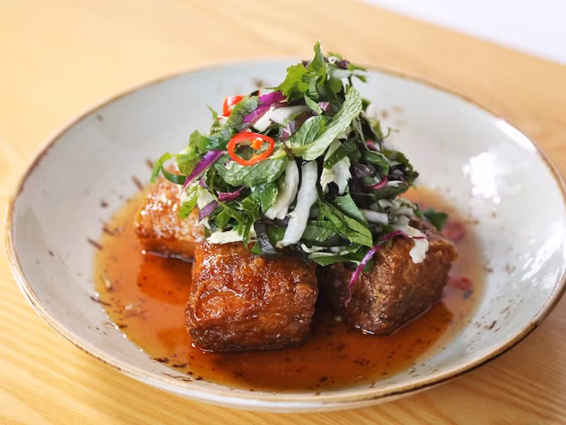 Món thịt lợn chiên giòn ăn kèm sốt táo, caramel và giấm đen là món ngon nổi tiếng ở Melbourne. 