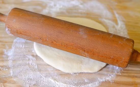 Bước 3: Chia bột vỏ bánh làm 2 phần bằng nhau, viên tròn, cán phẳng, bỏ nhân vào giữa vo kín rồi đặt vào khay ủ tiếp 1 tiếng rồi mới đem nướng. Ảnh: Chợ quê. 