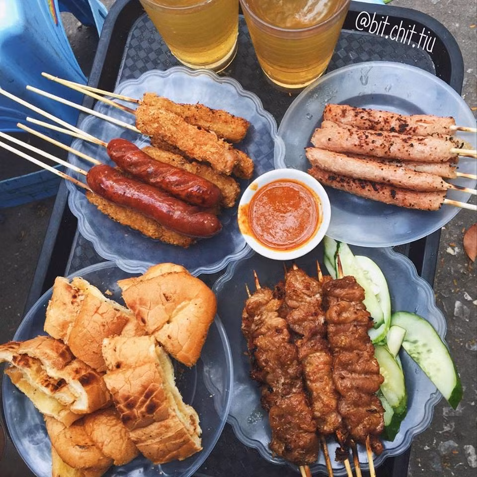Thịt xiên, bánh mì mật ong và nem chua rán chỉ 5 -10k/ cái ở Sân C5 Lương Định Của. Ảnh:Bitchittui.