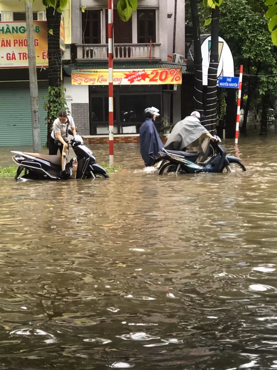 Nhiều người phải dắt phương tiện qua đoạn ngập sâu tại khu vực đường Nguyễn Khuyến. 