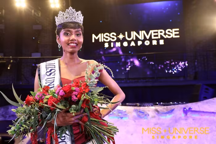 Được biết tân Hoa hậu Hoàn vũ Singapore 2019 là một sinh viên khoa học y sinh từ Học viện PSB và là một nhan sắc lai Ấn Độ.