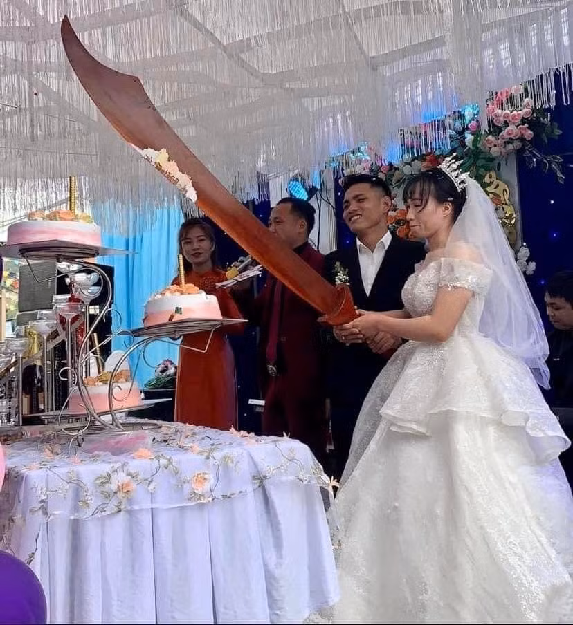 Không ít cặp đôi cô dâu chú rể từng có màn cắt bánh "bá đạo" tương tự. Những hình ảnh độc đáo tại một đám cưới diễn ra tại thị xã Hoàng Mai, tỉnh Nghệ An gây xôn xao khi dùng hẳn một cây "đồ long đao" siêu to khổng lồ để cắt bánh cưới.