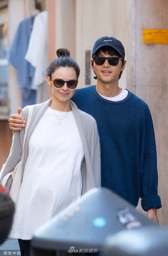 Hai vợ chồng nam tài tử xứ Hàn ăn mặc giản dị. Vợ Song Joong Ki búi tóc cao, không trang điểm và để lộ bụng bầu lùm lùm.