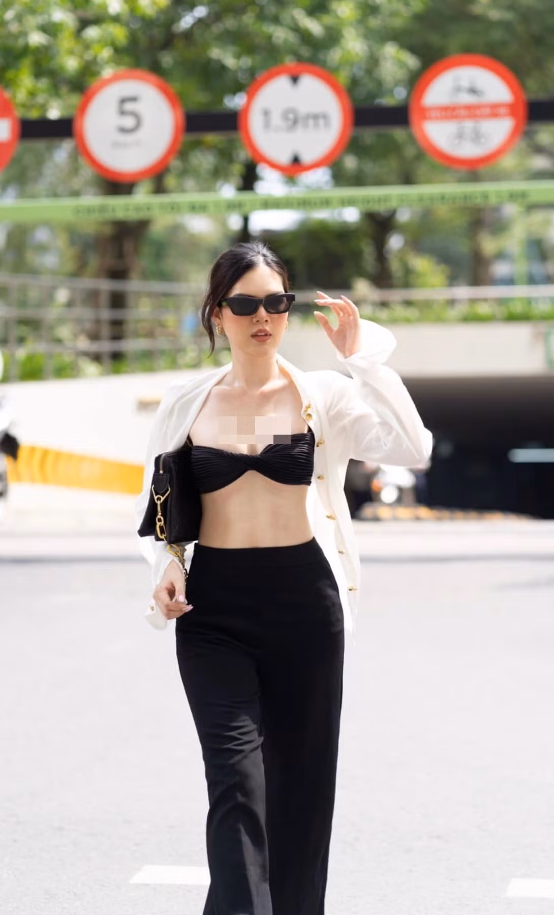 Mỹ nhân sinh năm 1996 diện đồ công sở nhưng lại phá cách bằng việc bung hết hàng cúc áo sơ mi trắng lộ nội y tối màu.