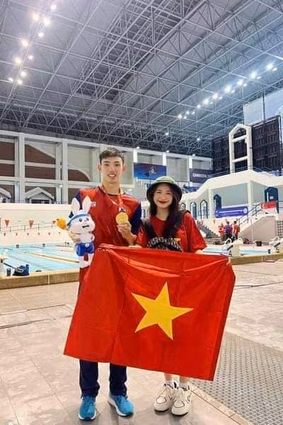 Người đẹp chụp cùng với nam VĐV bơi lội Việt Nam - Huy Hoàng.