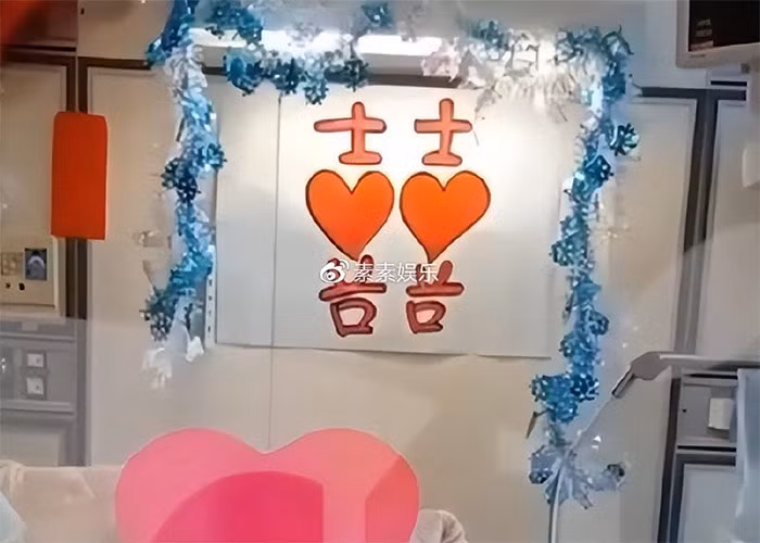 Trên đầu giường của Lý Khôn Thành là một tờ giấy chữ Hỷ do chính Lâm Tĩnh Ân viết. Cô gái sinh năm 1996 tay cầm chặt tờ đăng ký kết hôn và tạo dáng chụp ảnh với chồng đang nằm trên giường bệnh.