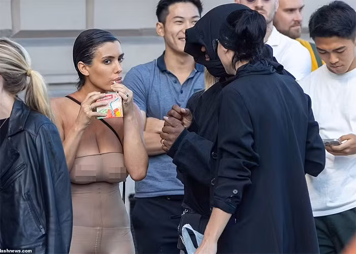 Phong cách thời trang kỳ quặc của hai vợ chồng Kanye West không khiến những người đứng xếp hàng cùng phải bận tâm, để ý. (Ảnh: Splasnews)