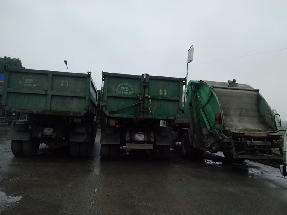 Các xe chở rác tập trung tại một cây xăng gần lối vào khu xử lý rác.