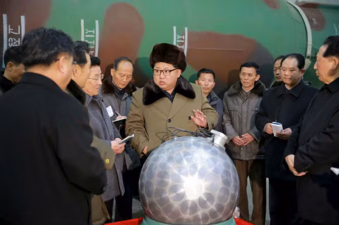 Nhà lãnh đạo Kim Jong-un gặp các nhà khoa học và chuyên gia kỹ thuật trong lĩnh vực nghiên cứu vũ khí hạt nhân. Bức ảnh ông Kim đứng trước mô hình đầu đạn hạt nhân thu nhỏ do Hãng thông tấn Trung ương Triều Tiên (KCNA) đăng tải ngày 9/3/2016.