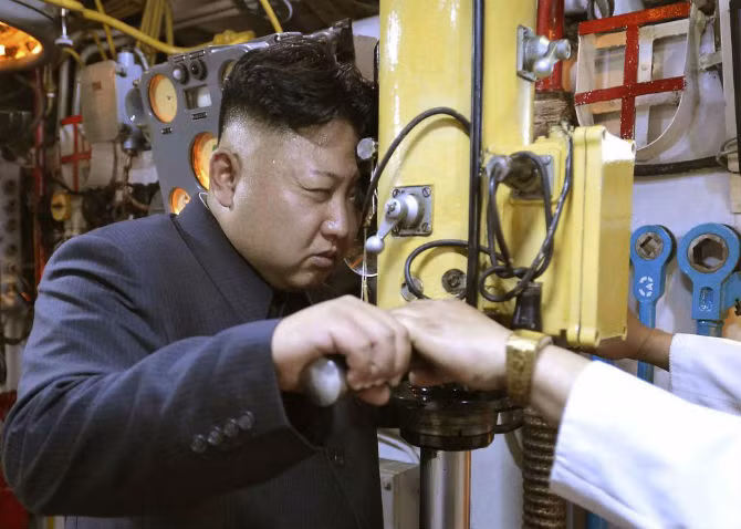 Nhà lãnh đạo Kim quan sát Đơn vị Hải quân 167 của KPA qua kính viễn vọng trên tàu ngầm. Ảnh do KCNA đăng tải ngày 16/6/2014.