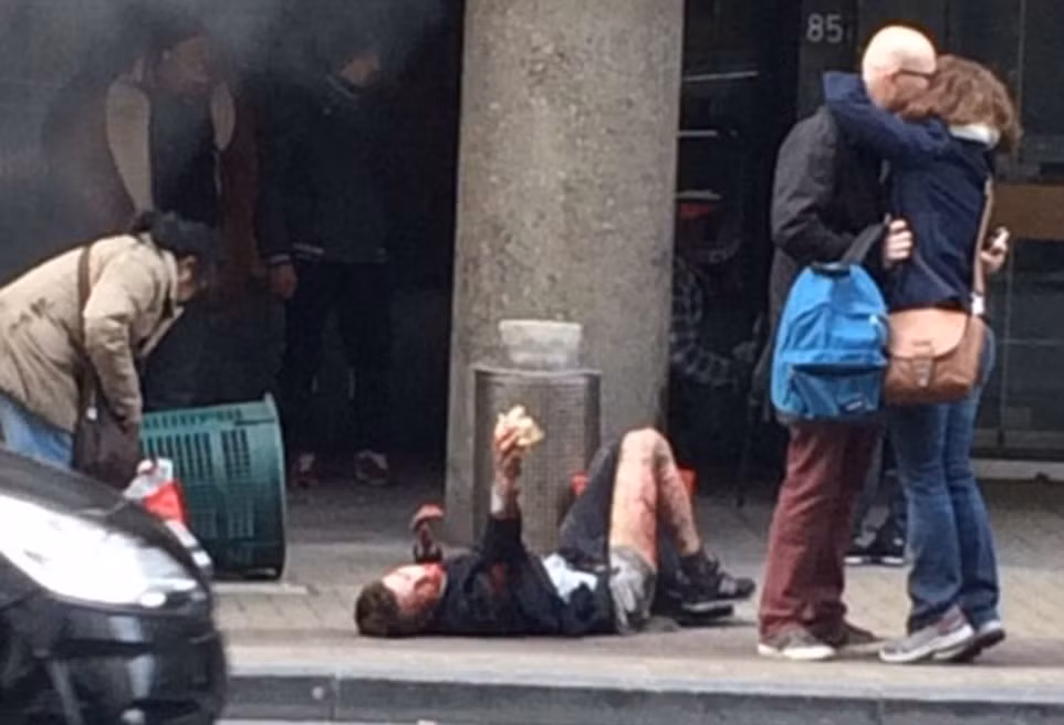 Một người đàn ông bị thương nằm trên vỉa hè tại khu nhà ga tàu điện ngầm ở Maalbeek.