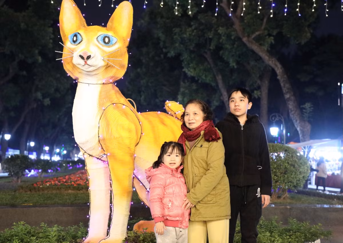Người dân thích thú chụp ảnh bên linh vật Mèo (Xuân Quý Mão 2023) được xây dựng trong Công Viên Thống Nhất.