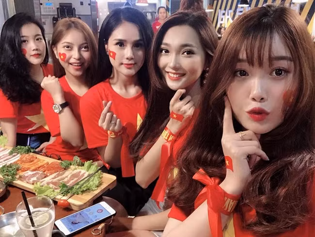 Huyền Trang hội ngộ dàn bạn gái của các thủ tuyển Việt Nam khi tập trung xem đá bóng cổ vũ cho đội nhà tại vòng tứ kết Asian Cup 2019. Hoàng Anh (bạn gái Văn Hậu), Nhật Lê (bạn gái Quang Hải), Huyền Trang (bạn gái Trọng Đại), Ngọc Nữ (người yêu tin đồn của Phan Văn Đức) và Trang Nhung (bạn gái Văn Toàn) (từ trái qua phải) mặc áo cờ đỏ sao vàng, khoe nhan sắc rạng rỡ.