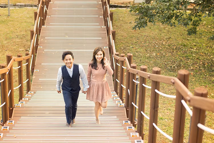 Hình ảnh Tiến Đạt nắm tay bà xã 9x dạo bước trên cây cầu gỗ.