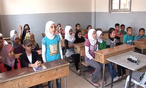 Các em học sinh Syria bắt đầu năm học mới tại thành phố Deir Ezor sau khi nơi này được giải vây. Ảnh: RT.