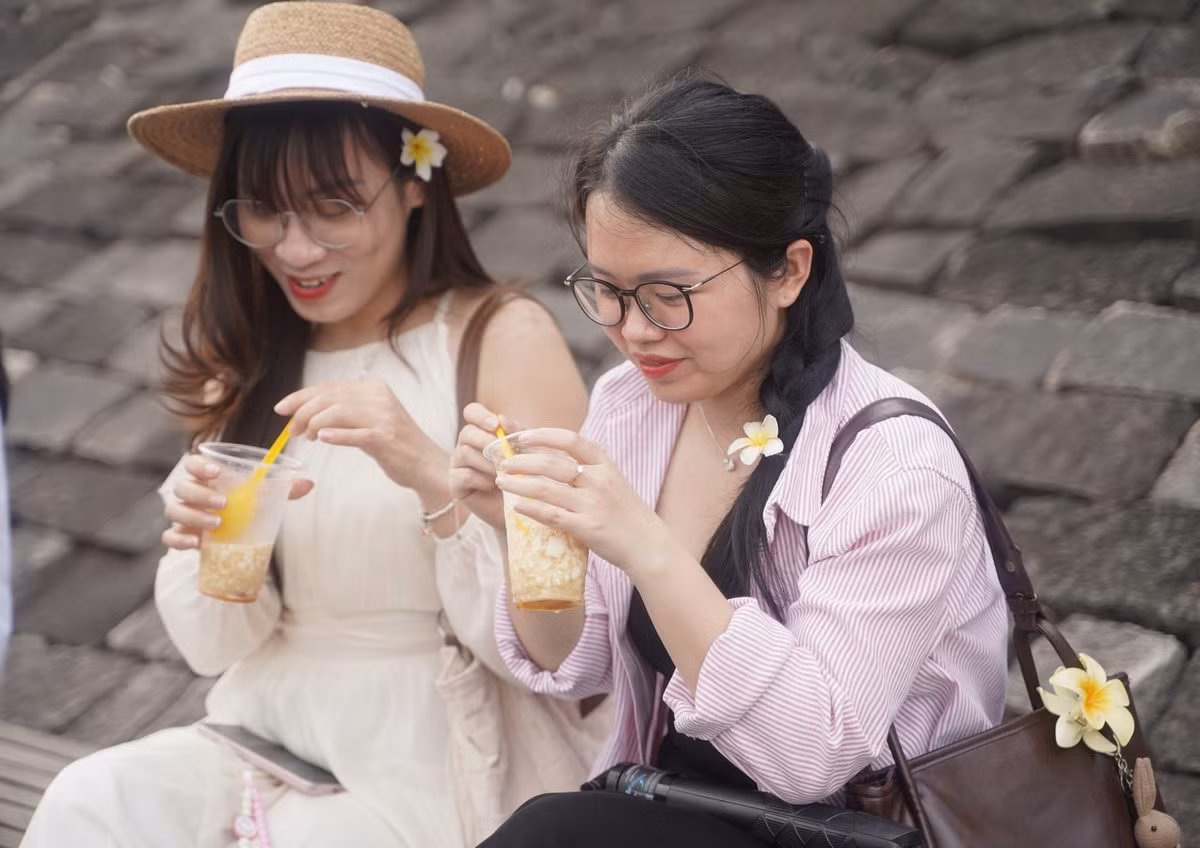 Nhiều bạn trẻ thích thú khi ngắm hoàng hôn và dùng đậu hủ bên dòng sông Hương thơ mộng. Ảnh: N.Q.