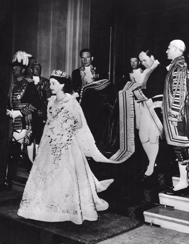 Không chỉ vương miện, Nữ hoàng Elizabeth II mặc bộ trang phục đẹp, thiết kế tinh xảo gắn nhiều vàng bạc châu báu. Do đó, bà bước đi một cách chậm rãi.