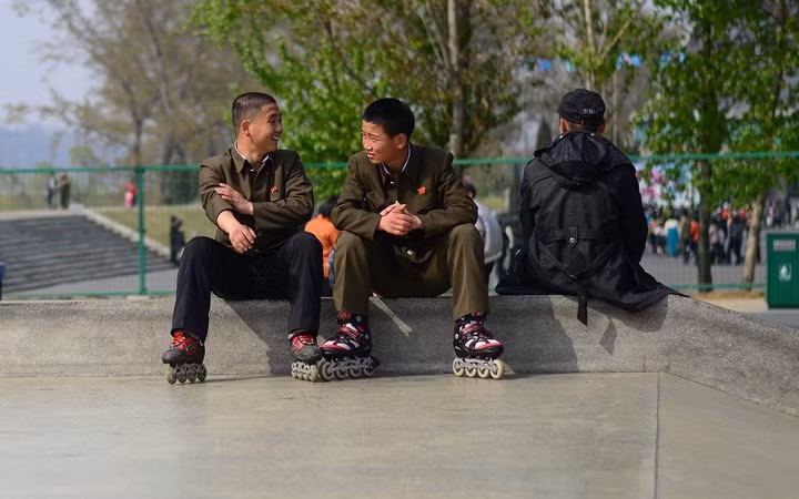 Thanh niên Triều Tiên nghỉ ngơi sau khi trượt patin tại một công viên ở Bình Nhưỡng.