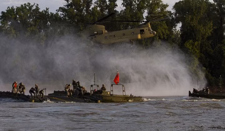 Trực thăng vận tải CH-47 Chinook hỗ trợ binh sĩ Mỹ dựng cầu tạm vượt sông trong cuộc tập trận tấn công đường sông tại Fort Knox.