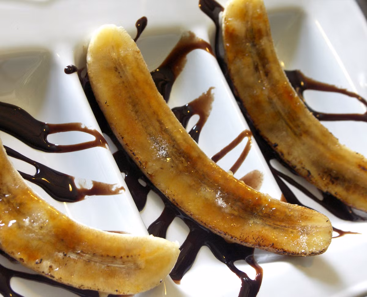 Caramel chuối chín: Chuối chín bỏ vỏ, thái lát mỏng vừa phải. Rắc một thìa cà phê đường vàng lên chuối, bỏ lên chảo lửa lớn để trong vòng 3-4 phút. Khi miếng chuối chuyển sang màu nâu, bạn tắt bếp, để nguội, rắc một ít bột quế lên trên hoặc cho thêm một chút rượu rum để làm dậy hương vị. Bạn đã có ngay một món tráng miệng caramel chuối đầy hấp dẫn. Ảnh: Internet. 