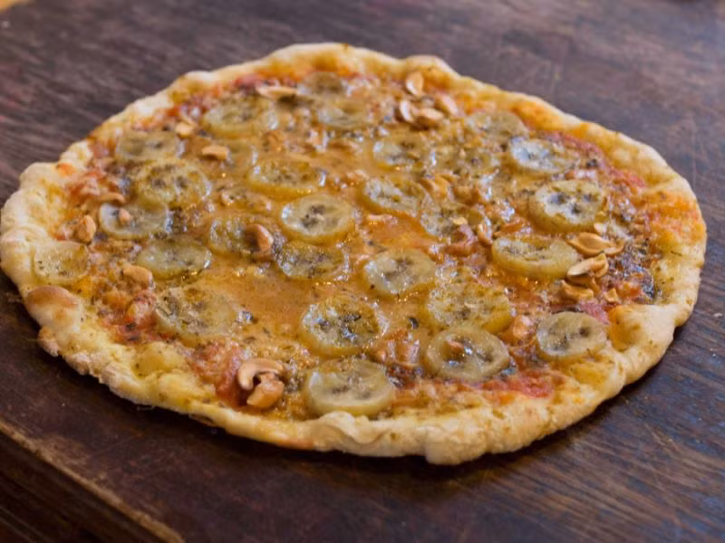 Món pizza chuối ở Thụy Điển. Đến đất nước này, nguyên liệu làm pizza sẽ đặc biệt một chút với cà ri, chuối chín cùng dăm bông hun khói.