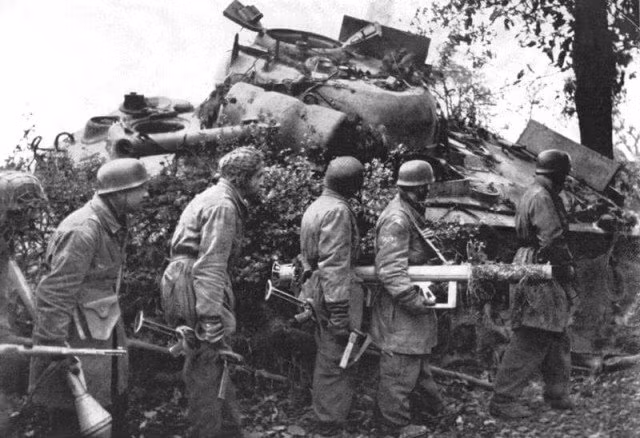 Lính Đức với súng chống tăng Panzerschreck và Panzerfaust - họ vừa bắn cháy một xe tăng Sherman. Ước tính, lực lượng quân sự Đức tham gia phòng thủ bức tường Đại Tây Dương lên tới 38 vạn người. Nguồn ảnh: WHS