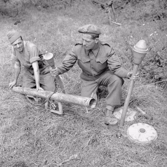 Lính Anh đang xem xét khẩu súng chống tăng Panzerschreck, Panzerfaust và mìn chống tăng sau khi giành thắng lợi ở Normandy. Nguồn ảnh: WHS