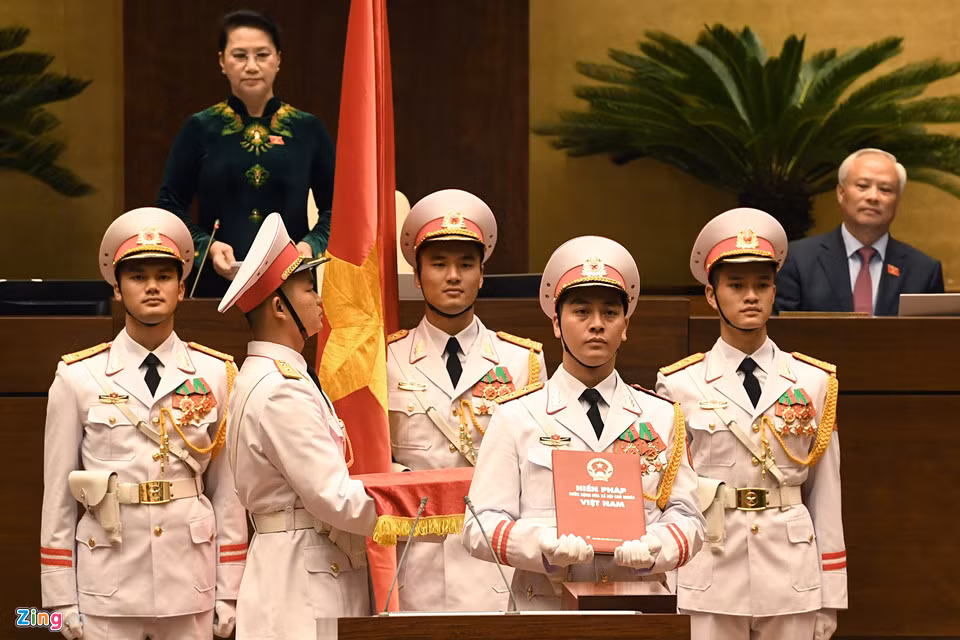 Đội nghi lễ tiến vào trong tiếng nhạc, mang theo cờ và Hiến pháp.