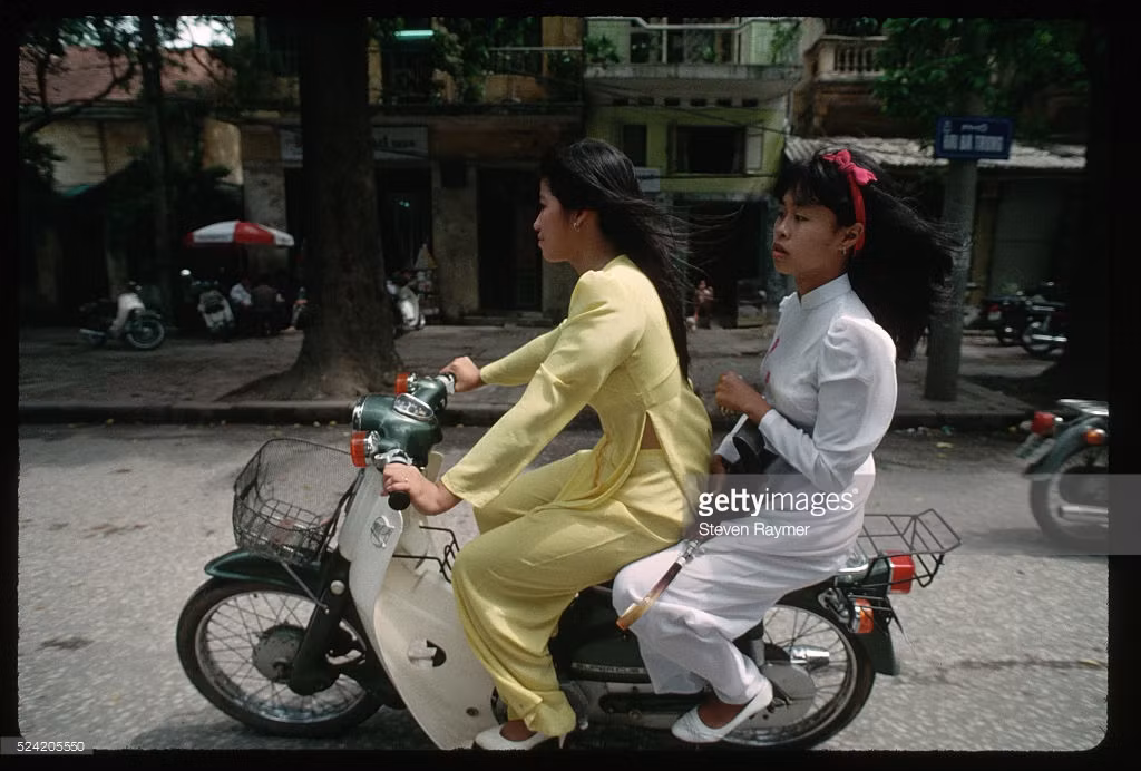Hai nữ sinh trường Trưng Vương rời trường trên xe máy sau lễ khai giảng.