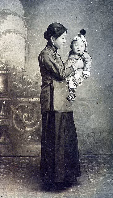 Người mẹ với ánh mắt trìu mến, đầy ắp tình yêu thương khi bế con trai nhỏ trong tay.