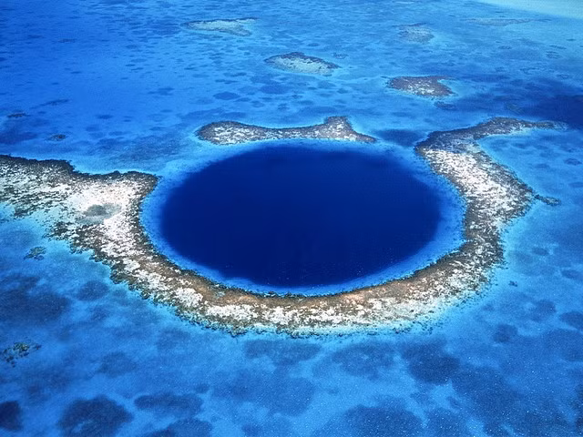 Lặn sâu vào Great Blue Hole huyền thoại. Nằm 60 dặm ngoài khơi cách đất liền của Belize, Nam Mỹ, hiện tượng địa lý này là một vòng tròn hoàn hảo của ¼ dặm đường kính. Một phần của hệ thống Reef Reef, độ sâu của nước gây ra các cấu trúc đã được biết đến như những lỗ xanh trên khắp thế giới.