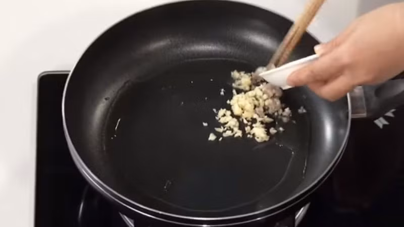 Bước 6: Thấy cá chín lấy ra, để dầu trong nồi, thêm hành, gừng, tỏi băm, ớt vào xào cho thơm, đổ một lượng nước sôi thích hợp, thêm muối, xì dầu, dầu hào, đường, rượu nấu ăn, khuấy đều cho đun sôi. (Ảnh: Bách hóa xanh)