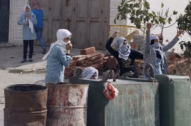Các cô gái Palestine ném đá trong cuộc đụng độ với người Israel ở thành phố Hebron, Bờ Tây.
