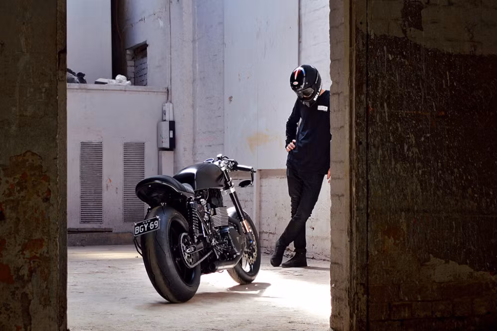 Bộ gắp sau của Triump Bonneville độ cafe racer được điều chỉnh phù hợp lốp size lớn hầm hố. Đèn đuôi và đèn xi nhan dạng LED của Kellermann được tích hợp nhỏ gọn bên dưới đuôi xe.