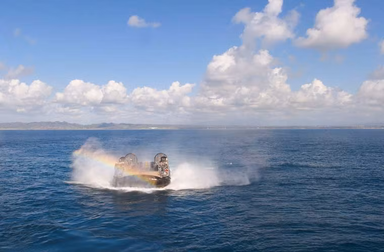 Tàu đổ bộ đệm khí LCAC thuộc biên chế tàu đổ bộ lớn USS Makin Island (LHD-8) đang rẽ sóng xuyên qua cầu vồng.