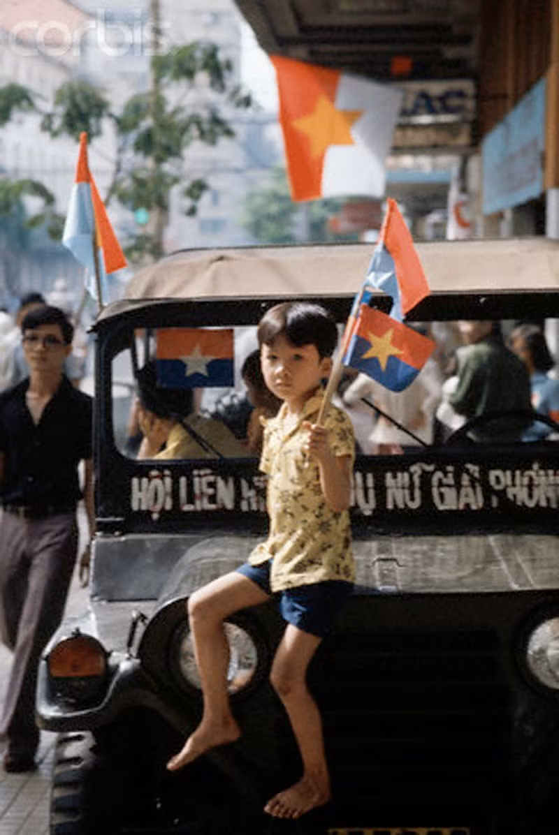 Một em bé ngồi trên xe jeep, tay cầm lá cờ vẫy chào các lực lượng giải phóng tiến vào Sài Gòn ngày 30/4/1975. Ảnh: Jacques Pavlovsky/Sygma/CORBIS.