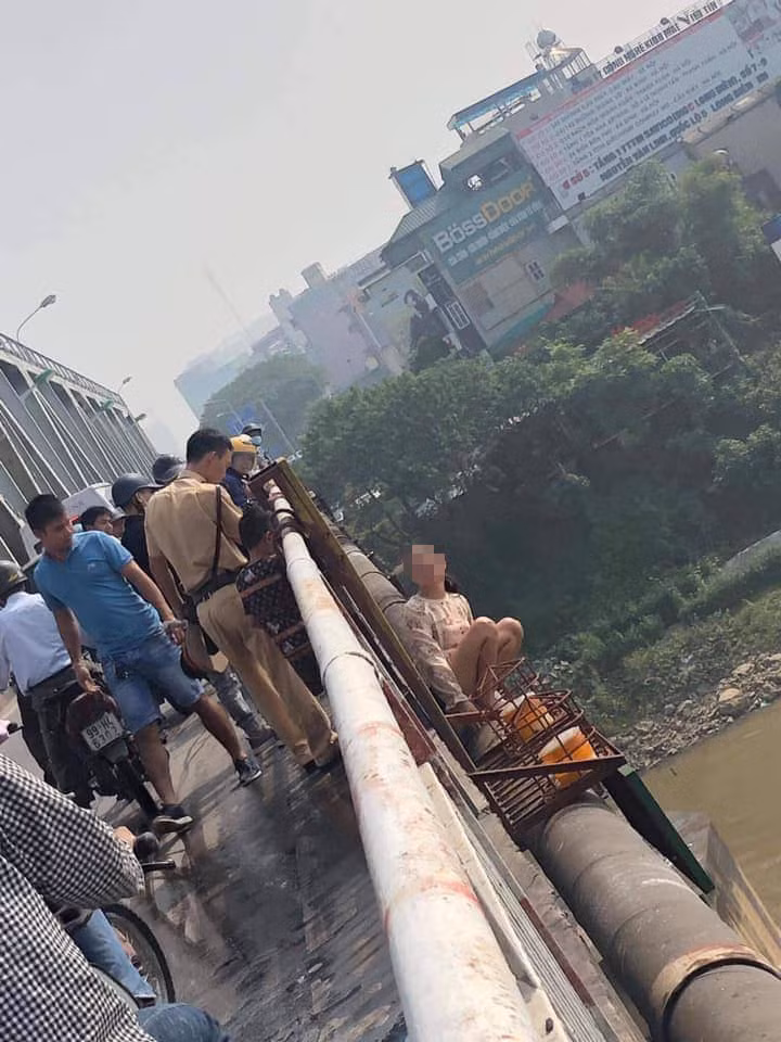 Tuy nhiên người phụ nữ này vẫn không phản ứng và trèo lên mép lan can định gieo mình xuống sông.