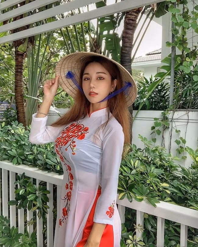 DJ Siena Hàn Quốc mặc áo dài kết hợp với nón lá nhưng để lộ nội y. Thông thường nội y trắng sẽ phù hợp hơn.