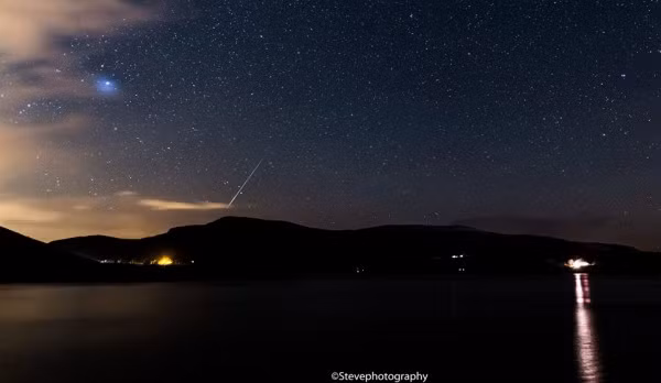 Nhiếp ảnh gia Steve chụp được khoảnh khắc tuyệt đẹp khi mưa sao băng Geminids bay ngang bầu trời ở Lough Talt, một hồ nước lớn ở Ireland.