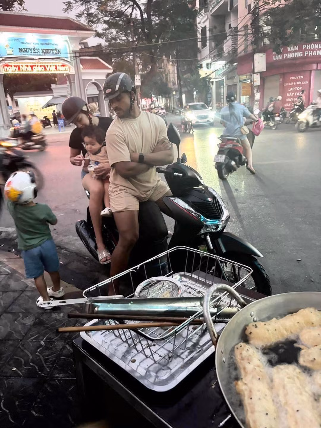 Trong bức ảnh, Xuân Son và bà xã Marcele Seippel xuất hiện với hình ảnh vô cùng đời thường. Hai người cùng nhau đi xe máy, mặc những bộ quần áo giản dị, đứng chờ mua bánh chuối như bao người khác.