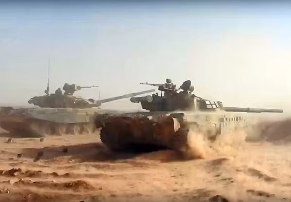 Xe tăng T-90 (bên trái) và T-72B (bên phải) đang khai hỏa pháo 125mm về phía mục tiêu.