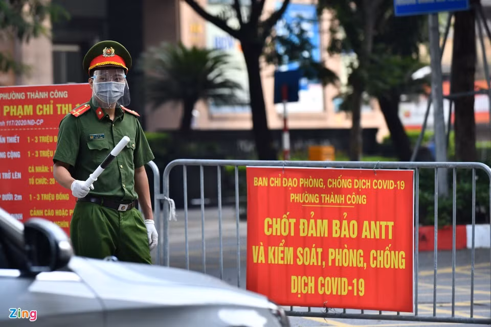 Thượng uý Lê Anh Dũng làm nhiệm vụ rà soát giấy người đi đường tại một chốt trên phố Giảng Võ. Tuy nhiên, để tránh tình trạng bị ùn ứ ở đầu chốt vào sáng thứ hai đầu tuần, nhiều chốt chặn phải nhanh chóng để cho xe đi qua.