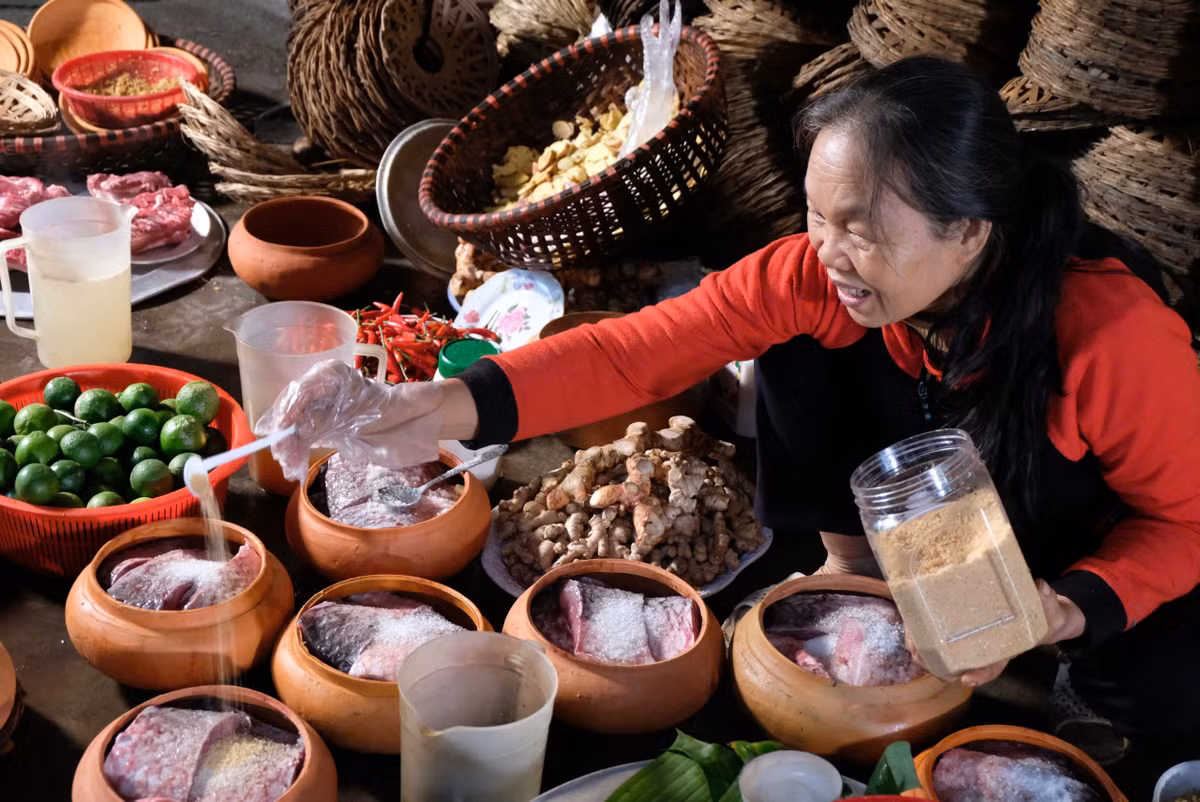 Bí quyết kho cá chuẩn vị quê hương “Bá Kiến” nằm ở cách hun khói, căn chỉnh lửa. Cá kho muốn hương vị thơm ngon phải được đun trong niêu đất và củi nhãn. Củi nhãn không chỉ khử được mùi tanh của cá, của đất nung mà còn làm cho cá đậm vị, có sự cay nồng, ngọt, bùi, béo, hòa quyện phảng phất hương vị khói củi nhãn. Khi kho cá, người thợ phải canh lửa lúc to, lúc nhỏ tùy từng thời điểm. Cá kho làng Vũ Đại được đun trong niêu đất liên tục từ 12 - 16 tiếng rồi tắt lửa, để om trên bếp tro củi cho đến khi nguội, mỡ trong cá tự vắt hết ra, miếng cá chắc lại, rất “đưa cơm”. (Ảnh: Tuyết Vân)
