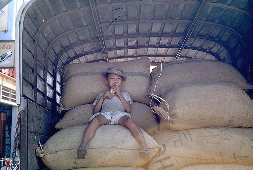 Em bé trên những bao gạo.