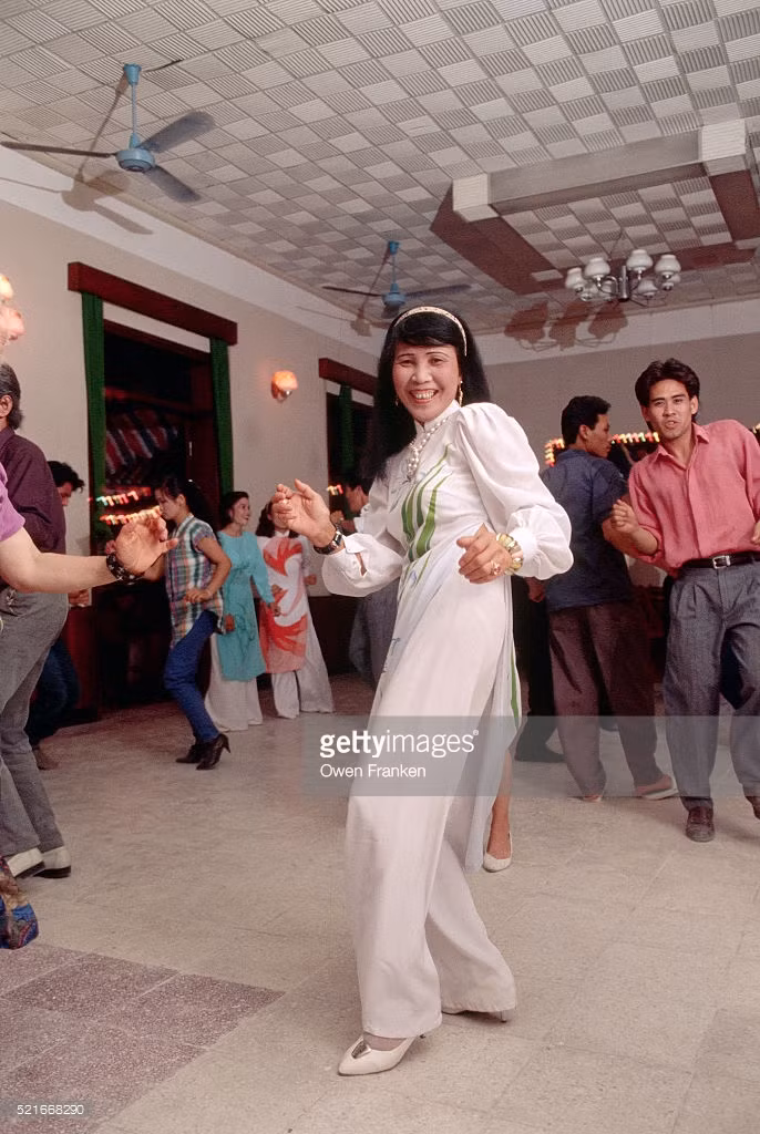 Cô gái trẻ mặc áo dài nhảy theo nhạc 'rock' n 'roll' tại một buổi tiệc ở Hà Nội.