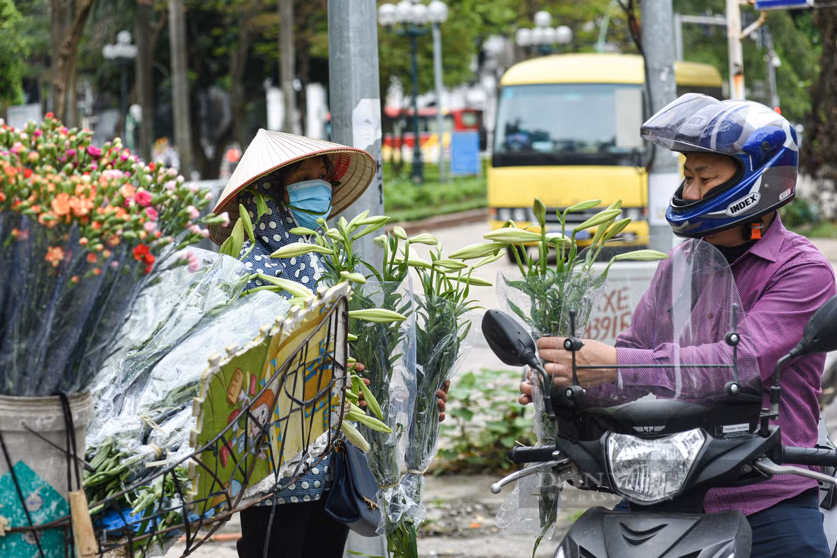 Dù vội đến mấy nhiều người vẫn sẵn lòng dừng chân ghé lại những gánh hoa ven đường để chọn mua vài cành loa kèn đầu mùa thật đẹp.