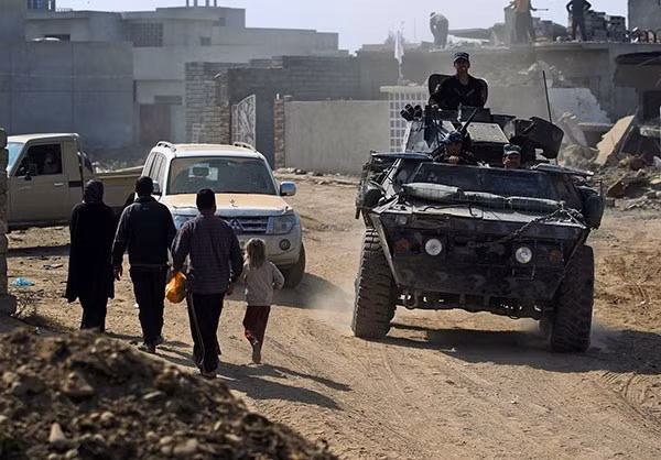 Xe quân sự của lực lượng chính phủ Iraq kéo vào bên trong khu dân cư ở tây Mosul. Ảnh FNA