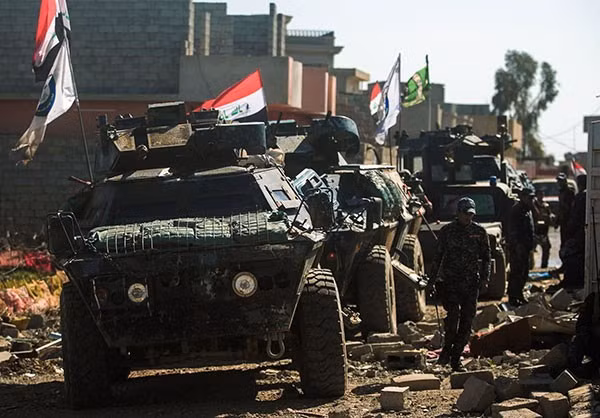 Đoàn xe quân sự Iraq rầm rập kéo vào một khu dân cư ở phía tây thành phố Mosul. Ảnh FNA