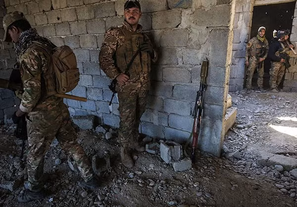 Các thành viên chính phủ Iraq lục soát một ngôi nhà sau khi họ cắt đứt tuyến đường tiếp tế cuối cùng của nhóm IS ở tây Mosul. Ảnh FNA